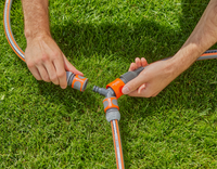 Hands connecting Gardena hose fittings on a grassy lawn., miniatuur 3