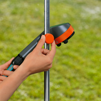 A person adjusting a Gardena garden sprinkler head on a metal pole in a grassy area., miniatuur 3