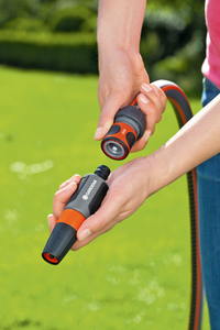 A person connecting a Gardena garden hose with a nozzle in a garden setting., miniatuur 2