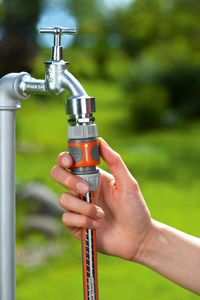 A person attaching a Gardena hose connector to an outdoor water tap., miniatuur 4