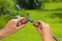 Hands connecting Gardena hose fittings in a garden setting., miniatuur 5