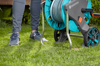 A person standing on grass next to a Gardena hose reel cart., miniatuur 3