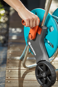 A person adjusting a Gardena hose reel on a wooden deck., miniatuur 5