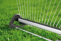 Close-up of a garden rake with multiple tines on a grassy lawn., miniatuur 5