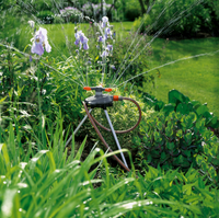 A garden sprinkler watering plants and flowers in a lush garden setting., miniatuur 3
