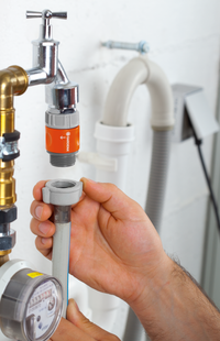 A person connecting a Gardena hose adapter to a water tap in a utility room., miniatuur 5