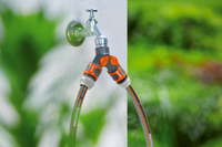 A dual garden hose connector attached to an outdoor faucet., miniatuur 4