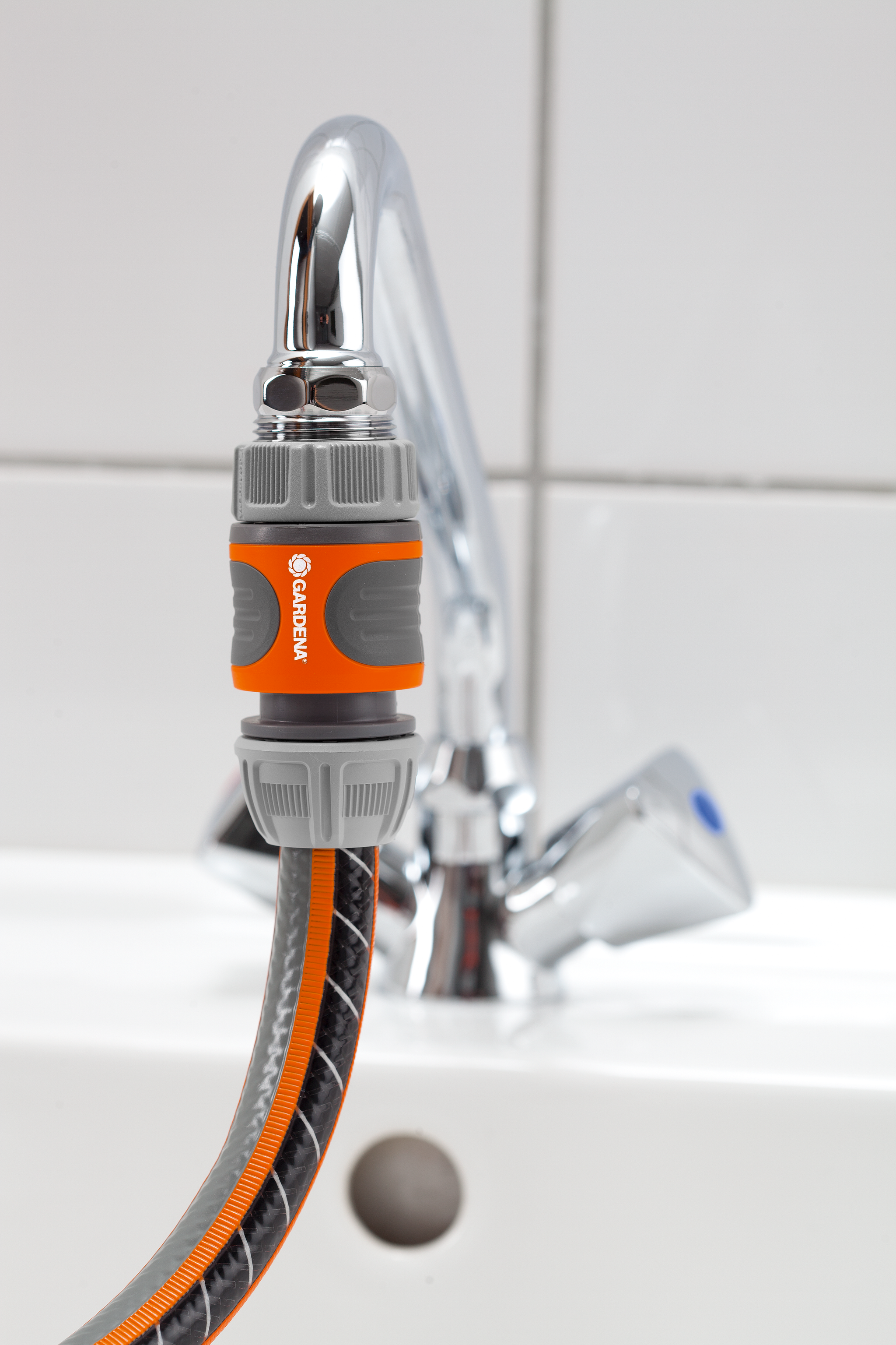Gardena hose connector attached to a faucet in a bathroom setting.