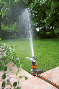 A garden sprinkler watering a lawn, surrounded by greenery and flowers., miniatuur 3