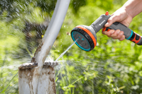 A person using a Gardena spray nozzle to clean a muddy shovel outdoors., miniatuur 5