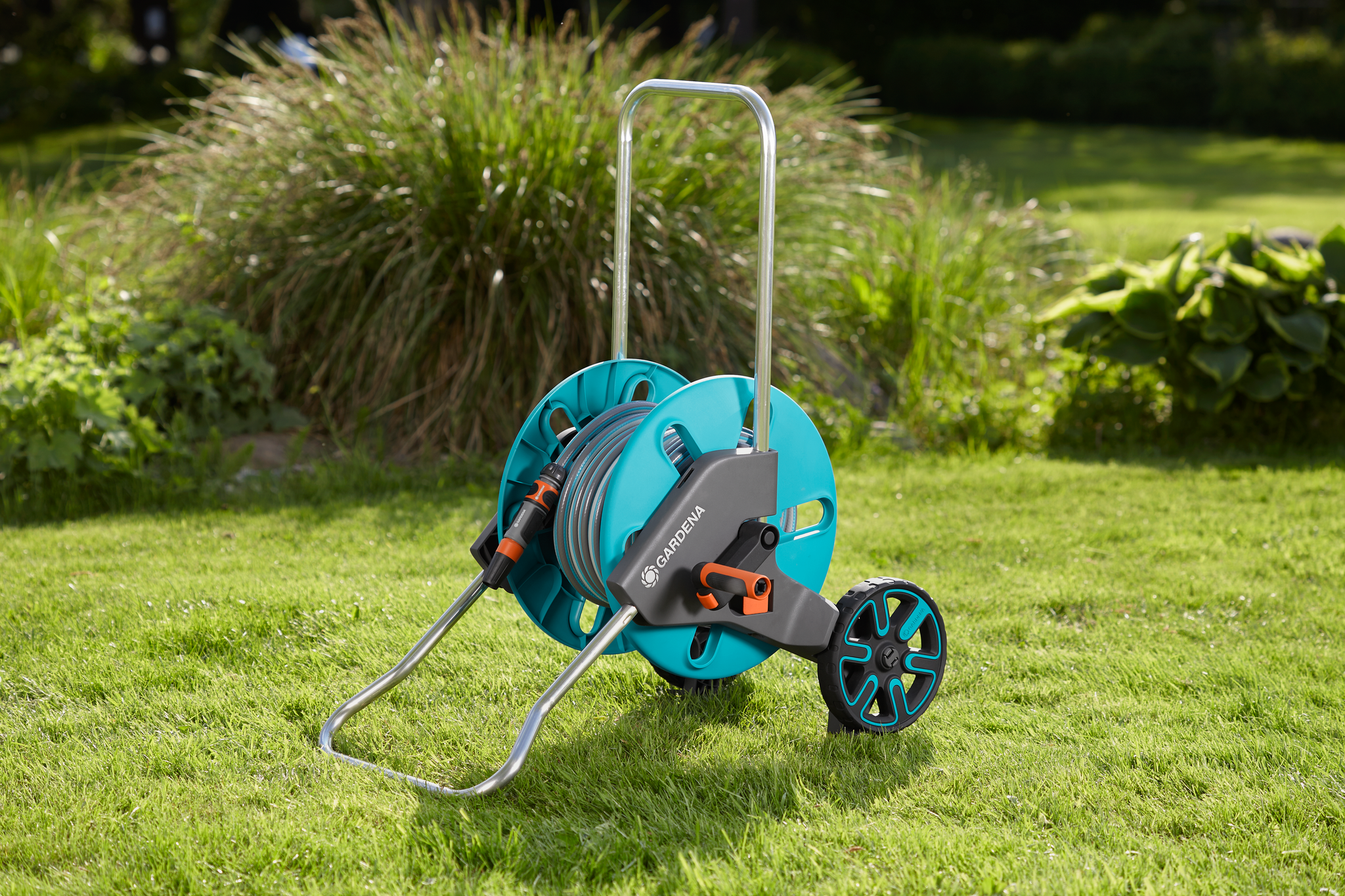 Gardena hose reel with wheels on a grassy lawn.