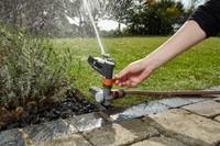 A person adjusting a garden sprinkler in a landscaped garden., miniatuur 5