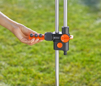 A person adjusting a Gardena water control valve in a garden setting., miniatuur 3