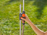 A person adjusting a Gardena water control system on a metal pole in a garden., miniatuur 4