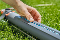 A person adjusting the settings on a garden sprinkler on a lawn., miniatuur 3