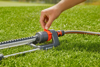 A person adjusting a Gardena garden sprinkler on a lawn., miniatuur 4