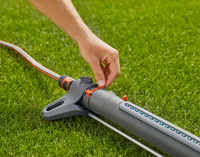 A person adjusting a Gardena garden sprinkler on a lawn., miniatuur 5