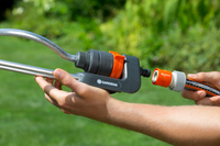 A person connecting a Gardena hose nozzle to a garden hose in a grassy area., miniatuur 3