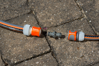 Gardena hose connectors and a coupler on a stone pavement., miniatuur 5