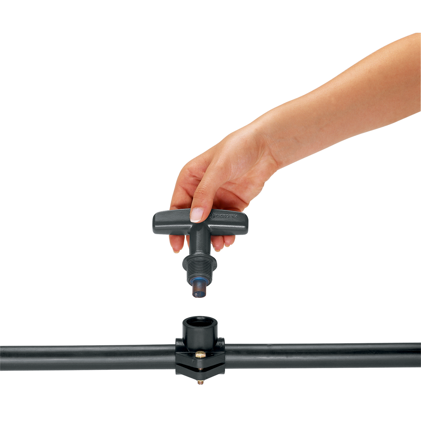 A hand installing a Gardena water valve onto a pipe.