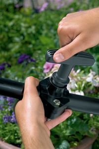 A person adjusting a garden irrigation valve in a flower bed., miniatuur 3