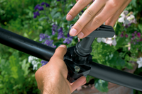 A person adjusting a Gardena irrigation valve in a garden setting., miniatuur 4