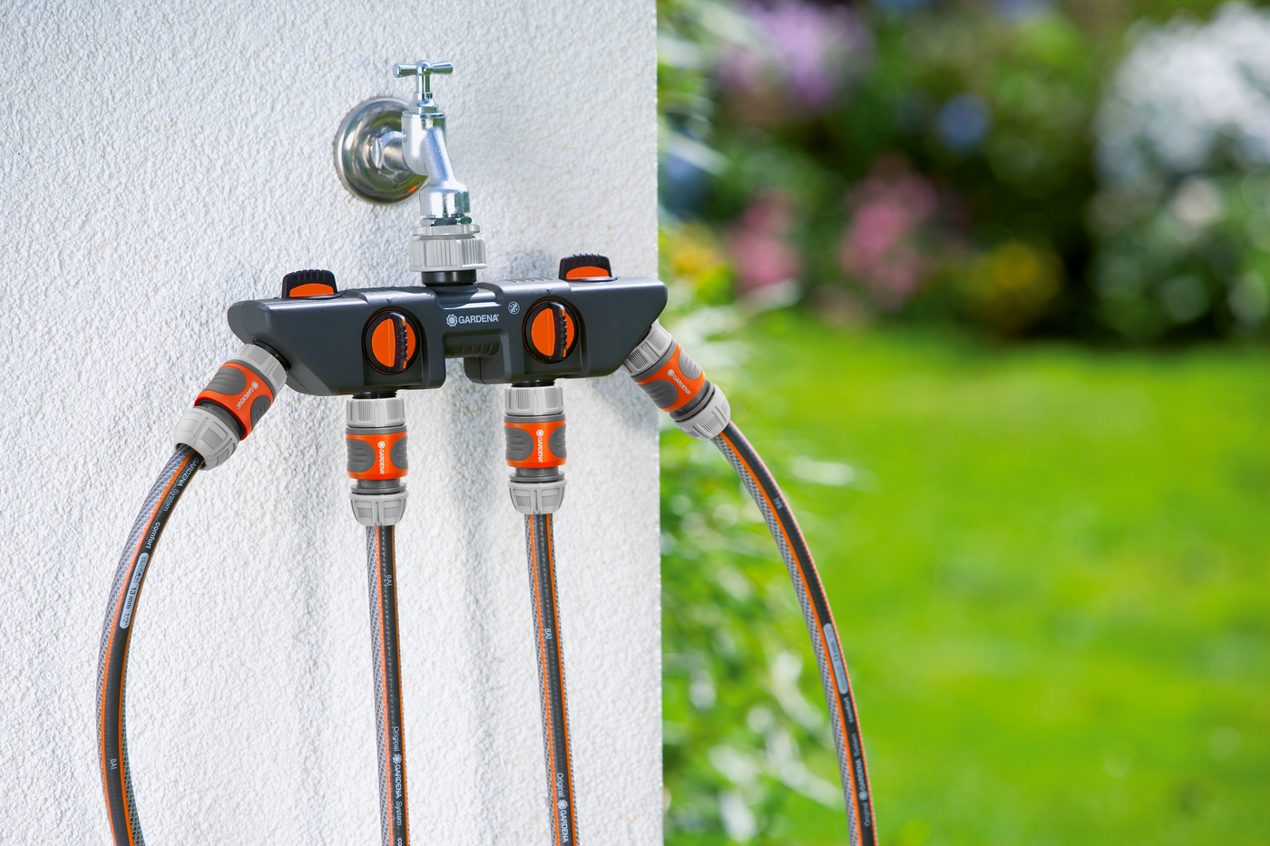 A Gardena water distributor connected to a garden tap with multiple hoses attached.