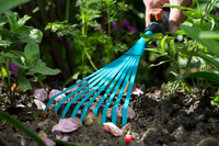A person using a Gardena hand rake to tend to a garden bed., miniatuur 4