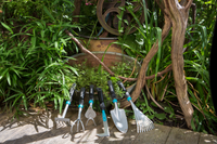 A set of Gardena gardening hand tools displayed on a wooden deck surrounded by lush greenery., miniatuur 4