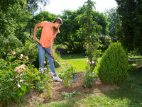 A person using a Gardena garden tool to tend to plants in a garden., miniatuur 2