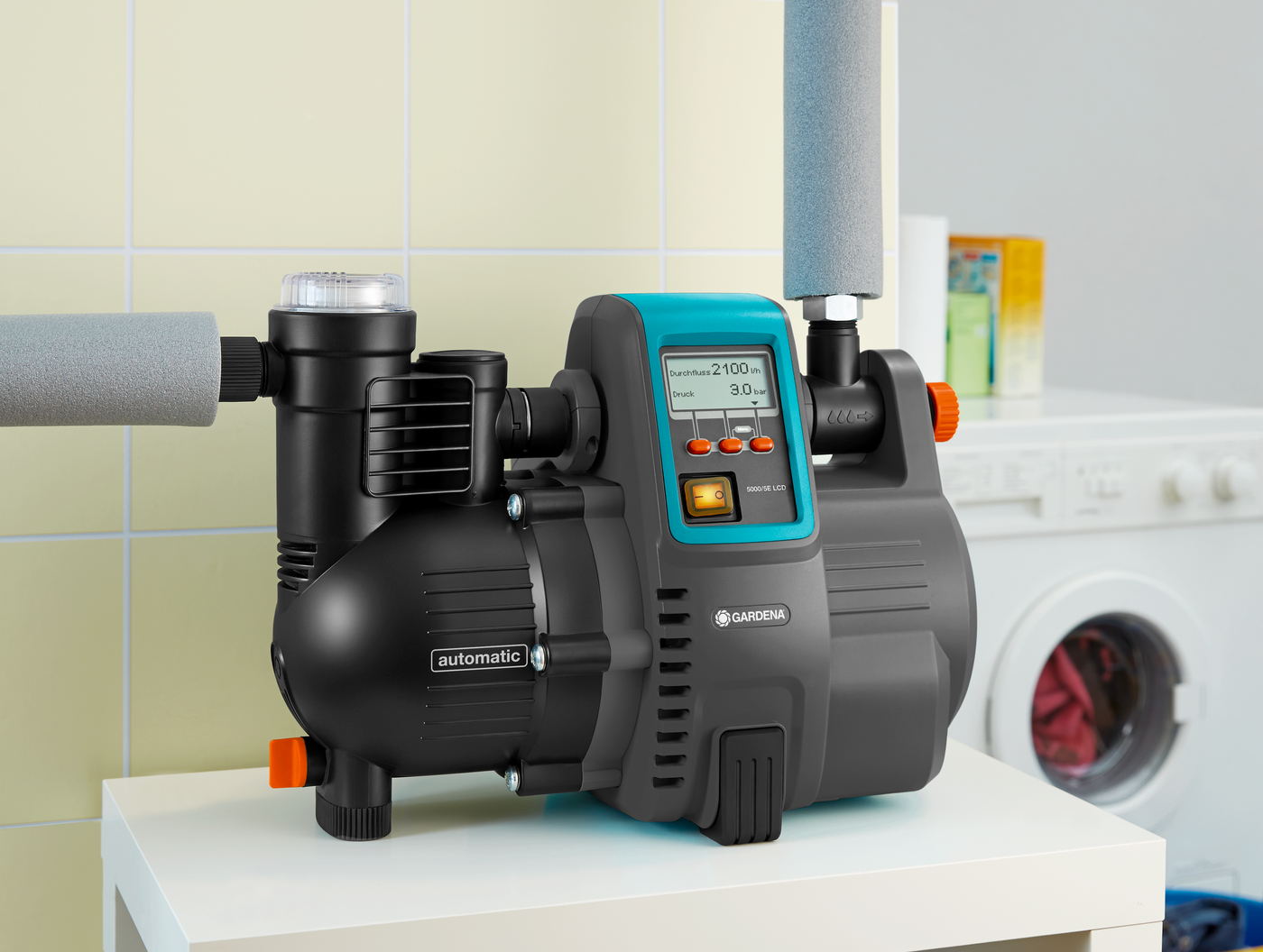 Gardena automatic water pump displayed indoors next to a washing machine.