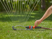 A person adjusting a garden sprinkler on a lawn., miniatuur 5