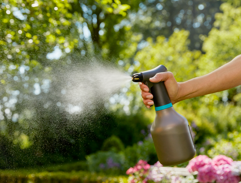 A person using a garden sprayer in a lush garden setting., afbeelding 4 Plantenspuiten