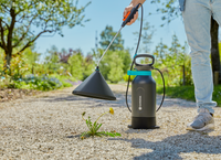 A person using a Gardena weed killer sprayer on a gravel path., miniatuur 2