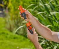 A person holding two Gardena hose connectors in a garden setting., miniatuur 5