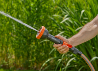 A person holding a Gardena garden hose nozzle, spraying water in a garden., miniatuur 6