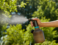A person using a Gardena spray bottle in a garden setting., miniatuur 3