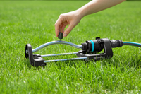 A person adjusting a Gardena lawn sprinkler on a grassy lawn., miniatuur 6