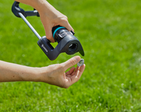 A person adjusting a Gardena garden sprinkler on a grassy lawn., miniatuur 5