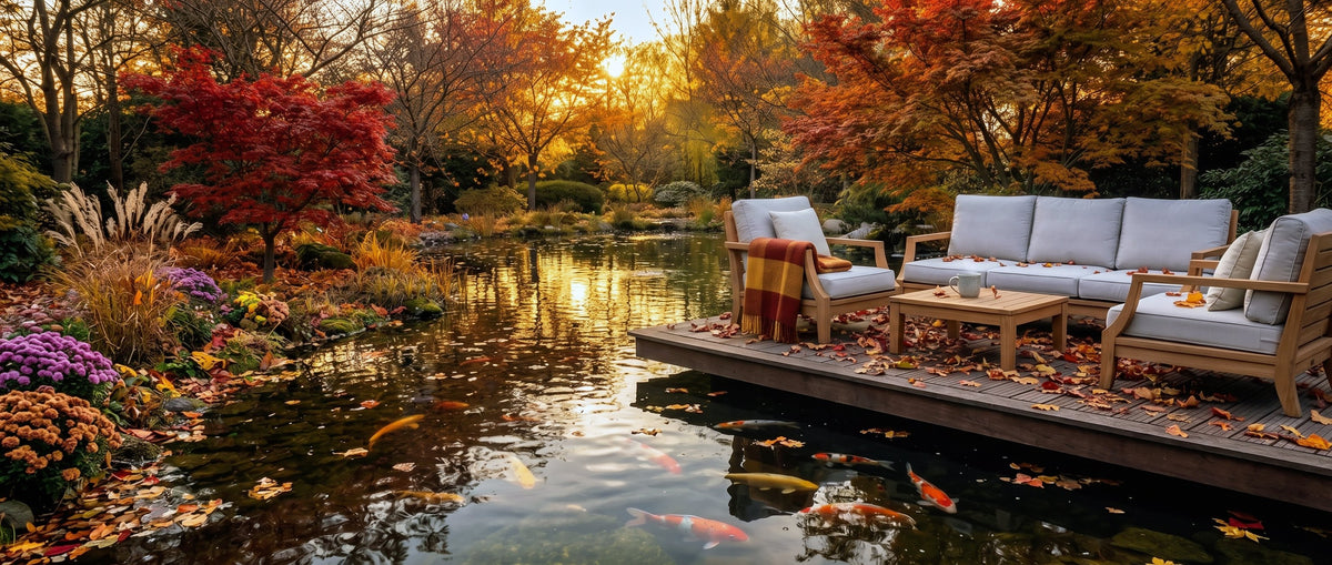 Herfstvijver met koi en een loungeset op de vlonder bij zonsondergang